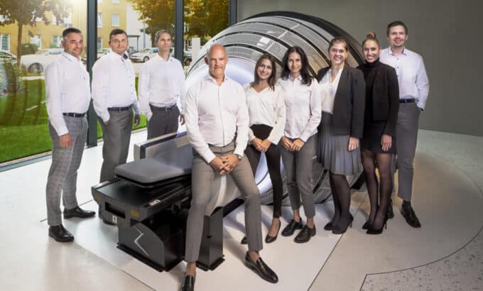 A group of people pose in front of the ZAP-X radiosurgery platform at the European Radiosurgery Center