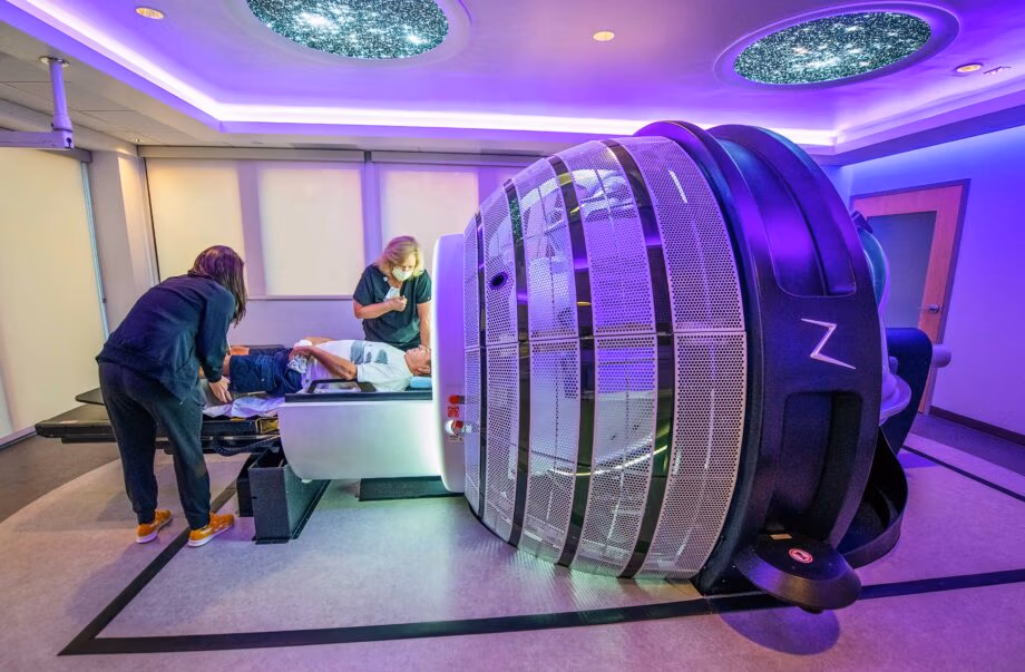 Patient is guided into treatment bed of ZAP-X for Neurosurgery One's first treatment using the new sterotactic radiosurgery robot